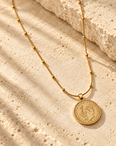 Collier médaille dorée — gros plan